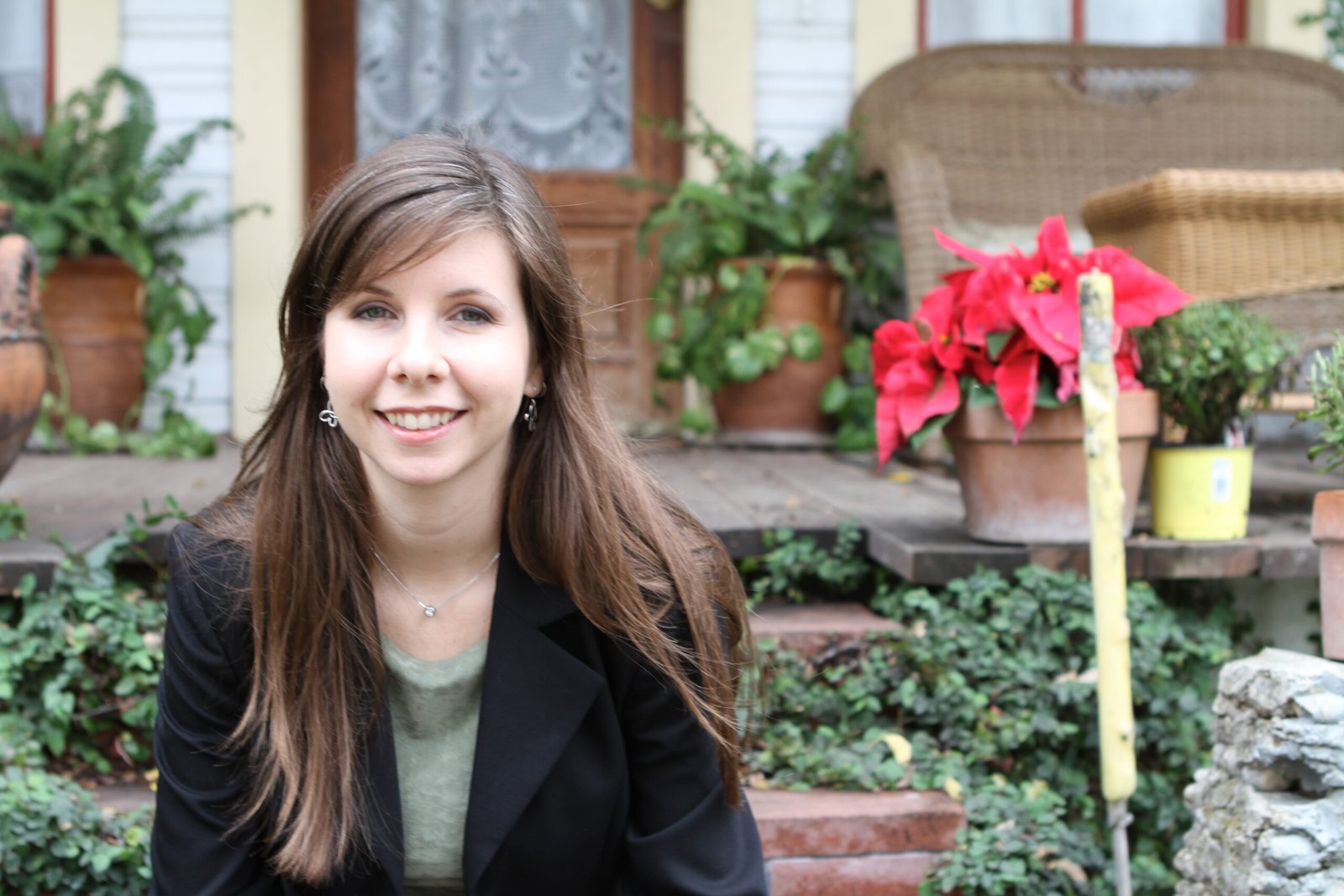 Ashley Festa smiling outdoors among potted plants